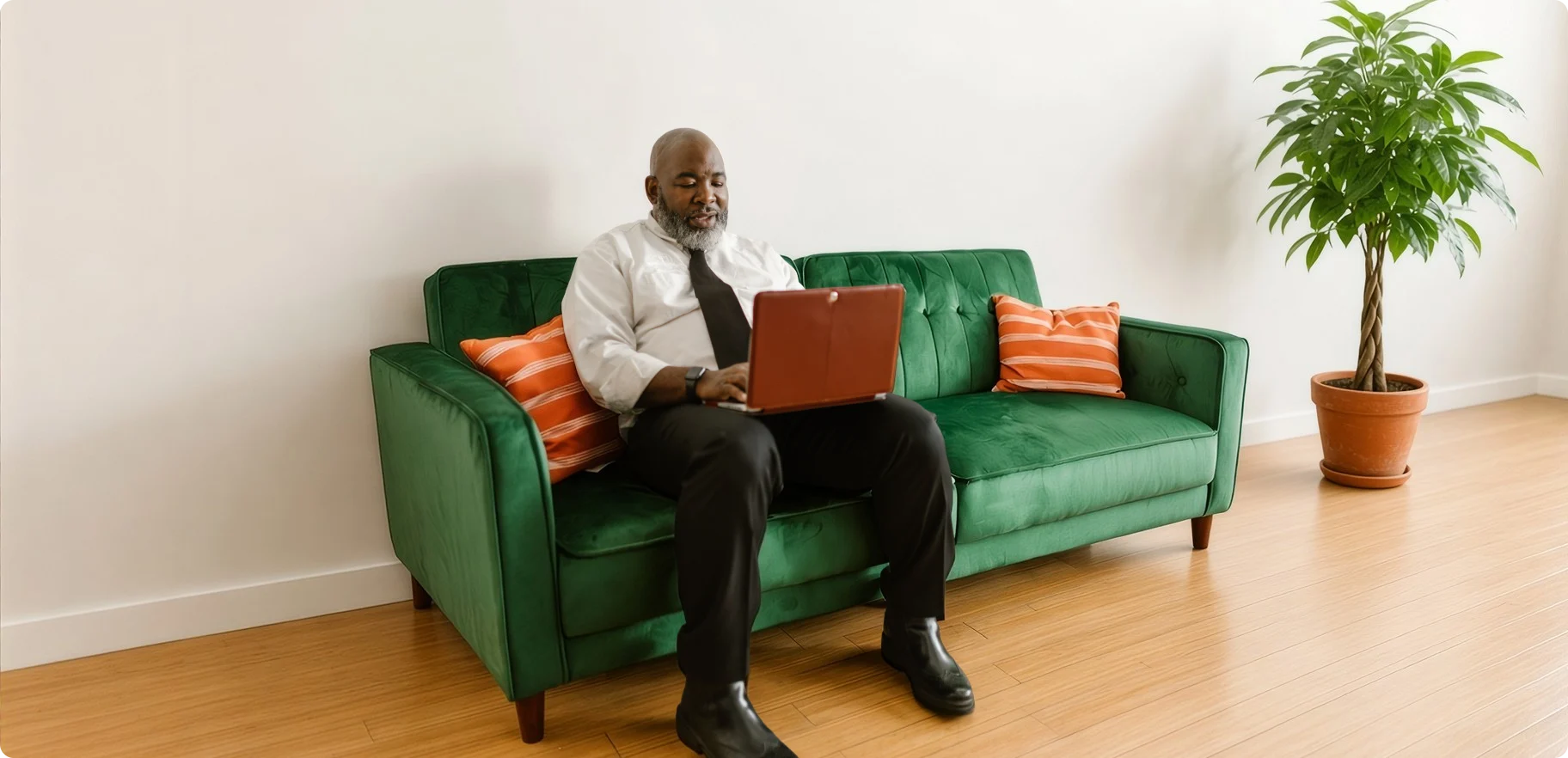 A man using a laptop on a green sofa